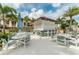 Outdoor pool bar and seating area featuring white tables, chairs, and palm trees, perfect for entertaining guests at 1720 Sawyer Palm Pl, Kissimmee, FL 34747