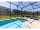 Beautiful in-ground pool and spa combination with a screened-in enclosure and a spacious patio at 1720 Sawyer Palm Pl, Kissimmee, FL 34747