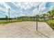 Sand volleyball court with net, surrounded by palm trees and lush landscaping, perfect for outdoor recreation at 1720 Sawyer Palm Pl, Kissimmee, FL 34747