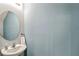 Bathroom featuring a round mirror, modern sink, and light blue wall at 2087 Crystal Bell St, Orlando, FL 32824