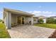 Spacious covered patio with brick pavers, sliding door, and manicured lawn at 2413 Park Ridge St, Apopka, FL 32712