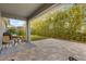 Open patio area with brick pavers, furniture, and a serene backdrop of bamboo and lush greenery at 2413 Park Ridge St, Apopka, FL 32712