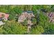 Aerial view of a grand home with a screened-in pool surrounded by mature trees and lush landscaping at 25603 High Hampton Cir, Sorrento, FL 32776