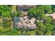 Bird's eye view of an estate, featuring a tile roof, screened-in pool, and mature trees at 25603 High Hampton Cir, Sorrento, FL 32776