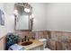 Stylish powder room featuring a decorative mirror, unique stone tile, and elegant sconce lighting at 25603 High Hampton Cir, Sorrento, FL 32776