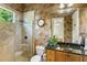 Modern bathroom with glass enclosed shower, beautiful tiled accent wall, and dark wood vanity at 25603 High Hampton Cir, Sorrento, FL 32776