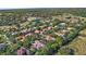 Scenic aerial perspective of a residential area highlighting lush greenery, serene lakes, and beautiful tile roofs at 25603 High Hampton Cir, Sorrento, FL 32776