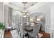 Sophisticated dining room with a large window, chandelier, and seating for six at 25603 High Hampton Cir, Sorrento, FL 32776