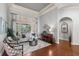 Living room featuring hardwood floors, neutral decor, a large window, and an arched doorway at 25603 High Hampton Cir, Sorrento, FL 32776