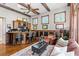 Inviting living room featuring a bar, beamed ceilings, wood floors, and comfortable seating at 25603 High Hampton Cir, Sorrento, FL 32776