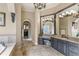 Lavish main bathroom features a jacuzzi tub, vanity area, elegant chandeliers, and marble tile at 25603 High Hampton Cir, Sorrento, FL 32776