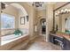 Lavish main bathroom features a jacuzzi tub, vanity area, elegant chandeliers, and marble tile at 25603 High Hampton Cir, Sorrento, FL 32776