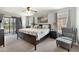 Spacious main bedroom with a king-sized bed, balcony access, and neutral décor at 302 Calabria Ave, Davenport, FL 33897