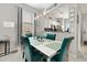 Modern dining room features a white table with blue chairs and views into the kitchen area at 302 Calabria Ave, Davenport, FL 33897