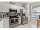 Bright kitchen featuring stainless steel appliances and white cabinets at 302 Calabria Ave, Davenport, FL 33897