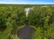 Aerial shot of a driveway leading to lake, surrounded by lush, mature trees at 3138 Lee Shore Loop, Orlando, FL 32820