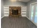 Cozy living room with built-in bookshelves, a stone fireplace, and stylish gray floors at 33348 Tewksbury Dr, Leesburg, FL 34788