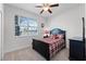 Quaint bedroom with a dark wood frame bed, black dresser, and a window providing natural light at 3492 La Jolla Dr, Clermont, FL 34711