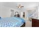 View of primary bedroom with an ensuite bathroom and walk-in closets, with a doorway to the side screened patio at 3492 La Jolla Dr, Clermont, FL 34711