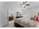 Well-lit bedroom showcases a view into the bathroom, ceiling fan, and neutral carpeting at 3492 La Jolla Dr, Clermont, FL 34711