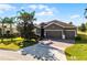 Beautiful home featuring a three-car garage, well-maintained lawn, and mature landscaping at 3492 La Jolla Dr, Clermont, FL 34711