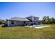 A lush green lawn leads to a stunning backyard with a pool and covered patio area at 36649 Forestdel Dr, Eustis, FL 32736