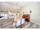 Spacious dining room featuring modern flooring, a charming light fixture, and adjacent kitchen space at 36649 Forestdel Dr, Eustis, FL 32736