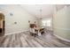 Open dining area with ample natural light, complemented by a classic piano and stylish wood-look floors at 36649 Forestdel Dr, Eustis, FL 32736