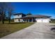 Inviting two-story home with a manicured lawn, an American flag, and a two-car garage at 36649 Forestdel Dr, Eustis, FL 32736