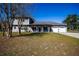 Inviting two-story home with a manicured lawn, an American flag, and a two-car garage at 36649 Forestdel Dr, Eustis, FL 32736