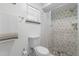 Updated bathroom with patterned shower tile and glass door and a toilet with a window at 412 Short Dr, Poinciana, FL 34759