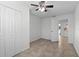 Bedroom with tile flooring, ceiling fan, closet, neutral walls and is adjacent to another room at 412 Short Dr, Poinciana, FL 34759