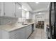 Bright kitchen featuring white cabinets, quartz countertops, and a mosaic tile backsplash at 412 Short Dr, Poinciana, FL 34759