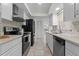 Modern kitchen with white cabinetry, stainless steel appliances, and mosaic tile backsplash at 412 Short Dr, Poinciana, FL 34759