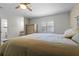 Bright main bedroom with a ceiling fan, window with plantation shutters and ensuite bathroom at 412 Short Dr, Poinciana, FL 34759