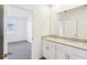 A bathroom showcasing a double vanity with granite counters and a view into a bedroom with a window at 4973 Kaia Ave, Winter Haven, FL 33884