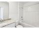 Bright bathroom featuring a granite vanity top and a tiled tub with shower at 4973 Kaia Ave, Winter Haven, FL 33884