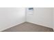 Empty bedroom with neutral carpet, white walls, and a window with blinds at 4973 Kaia Ave, Winter Haven, FL 33884