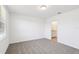 A carpeted bedroom featuring neutral walls, a window and an attached bathroom at 4973 Kaia Ave, Winter Haven, FL 33884
