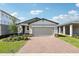 Charming single-story home with a brick driveway, light-colored exterior, and a two-car garage on a sunny day at 4973 Kaia Ave, Winter Haven, FL 33884