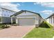 Charming single-story home features a brick driveway, light-colored exterior, and a two-car garage on a sunny day at 4973 Kaia Ave, Winter Haven, FL 33884