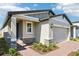 Charming single-story home with a brick driveway, light-colored exterior, and a two-car garage on a sunny day at 4973 Kaia Ave, Winter Haven, FL 33884