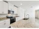 A modern kitchen with white cabinets, stainless steel appliances, and granite countertops with a large island at 4973 Kaia Ave, Winter Haven, FL 33884