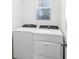 A laundry room featuring a white washer and dryer beneath a window with light filtering blinds at 4973 Kaia Ave, Winter Haven, FL 33884