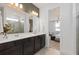 Bright bathroom featuring double sinks, a walk-in shower, and a view of the primary bedroom at 6017 Wildline Dr, St Cloud, FL 34771