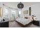 Sunlit main bedroom featuring a stylish woven light fixture, neutral palette, and a cozy seating area at 6017 Wildline Dr, St Cloud, FL 34771