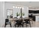 Dining room with a long table, modern black chairs, stylish lighting, and adjacent kitchen view at 6035 Wildline Dr, St Cloud, FL 34771