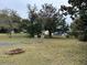 Large backyard with mature trees, picket fence and fire pit, perfect for outdoor gatherings at 63 Dahlia Dr, Debary, FL 32713