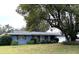 Charming single-story home with blue siding, shutters, and a well-manicured lawn at 63 Dahlia Dr, Debary, FL 32713