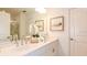 Bright bathroom boasts double sinks, white cabinets, framed art and a glass-enclosed shower for a spa-like experience at 674 Teviot Rd, Haines City, FL 33844